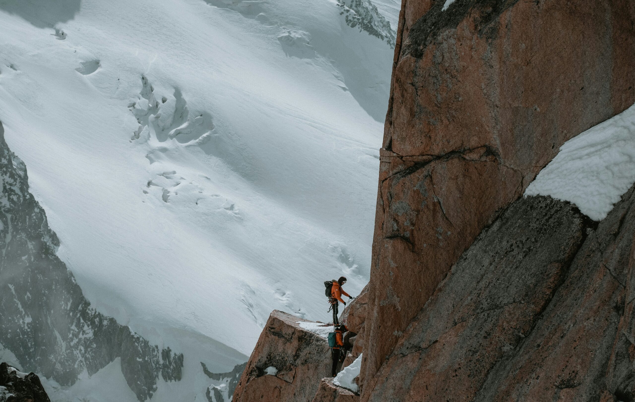 A climber inspecting and cleaning their ice screw piton after a day outdoors