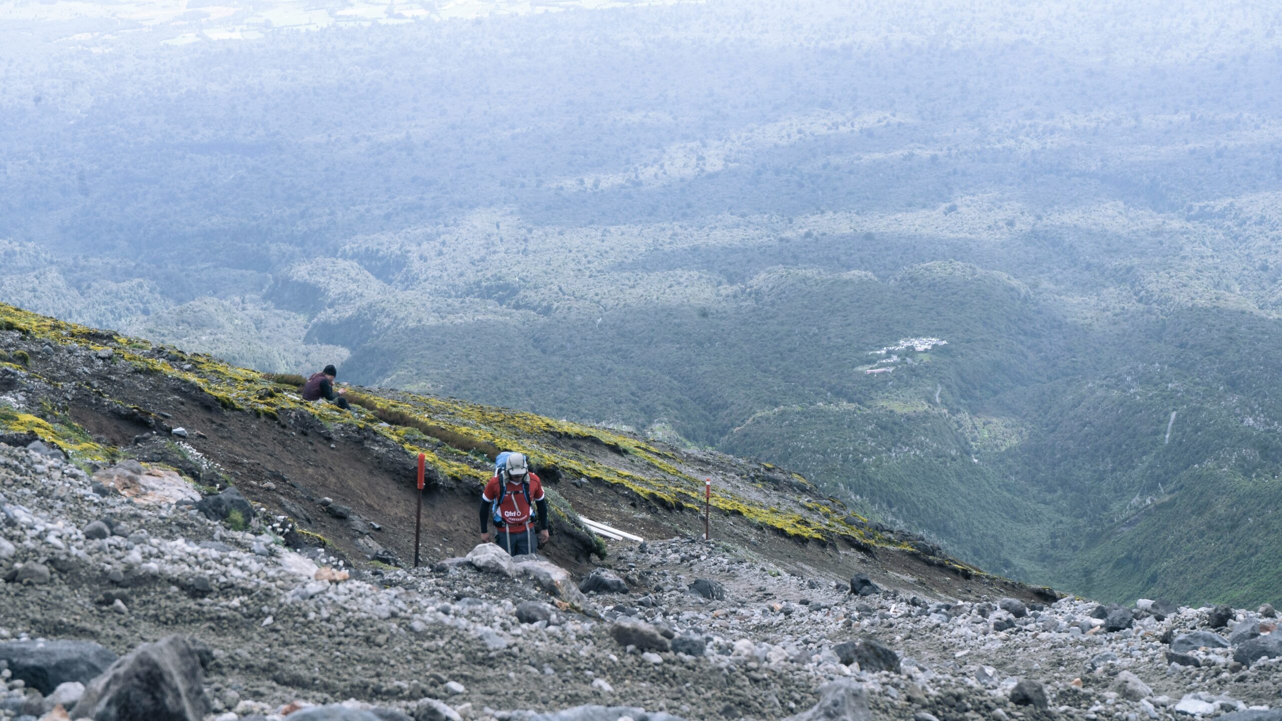 A rugged mountain cliff with climbing pitons anchored in rock, showcasing adventure gear essentials