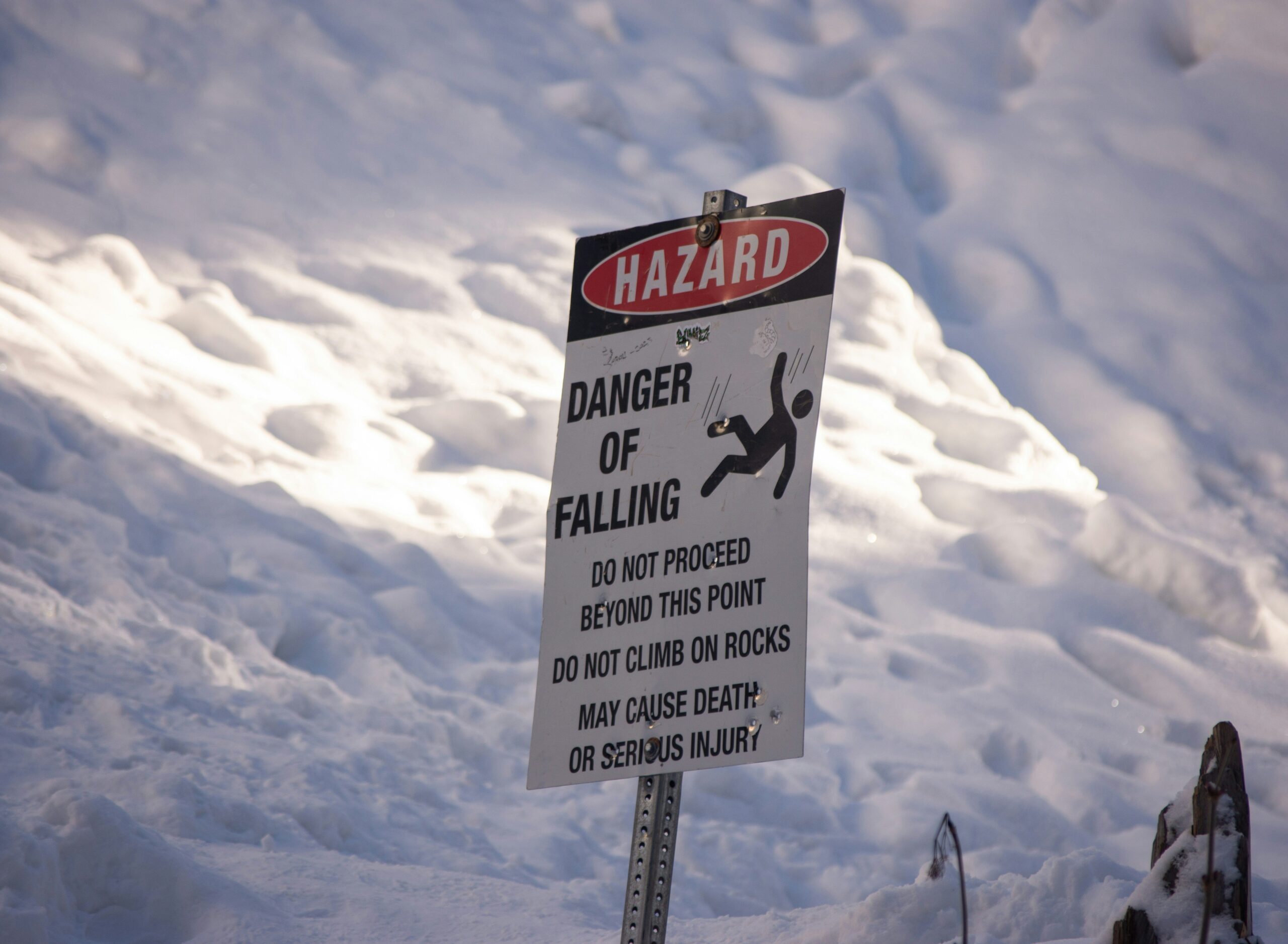 A climber hammering an ice piton