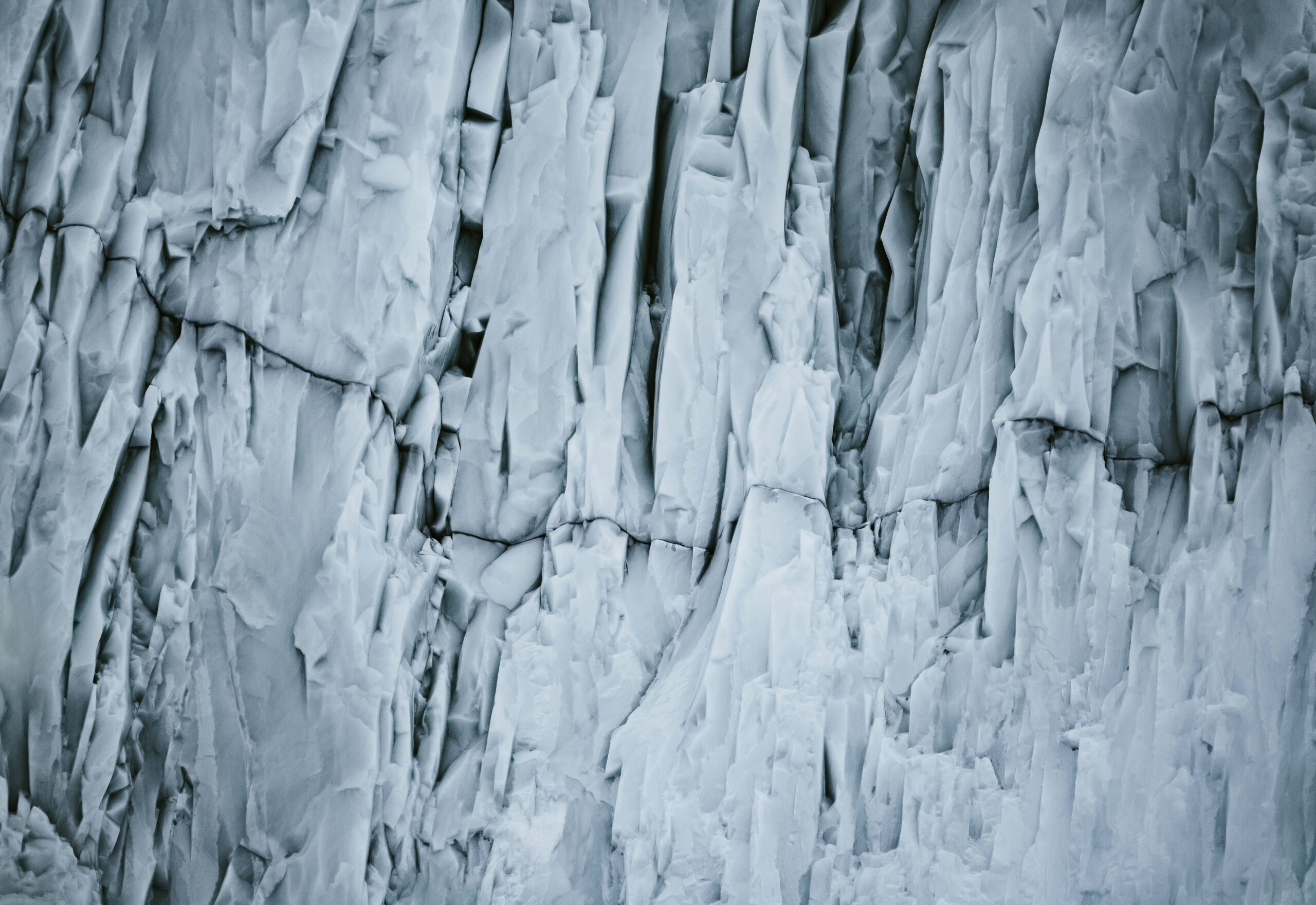 Climber using frozen terrain anchors on icy wall