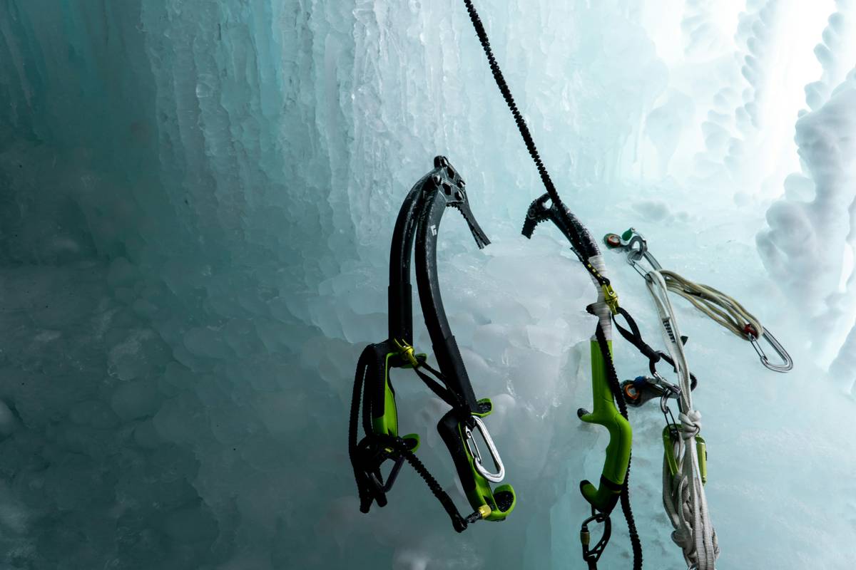 Climber struggling with a poor-quality ice piton hammer during ascent