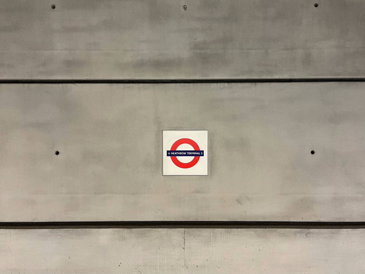 Climber using a piton hammer to secure a climbing piton on a rocky surface.