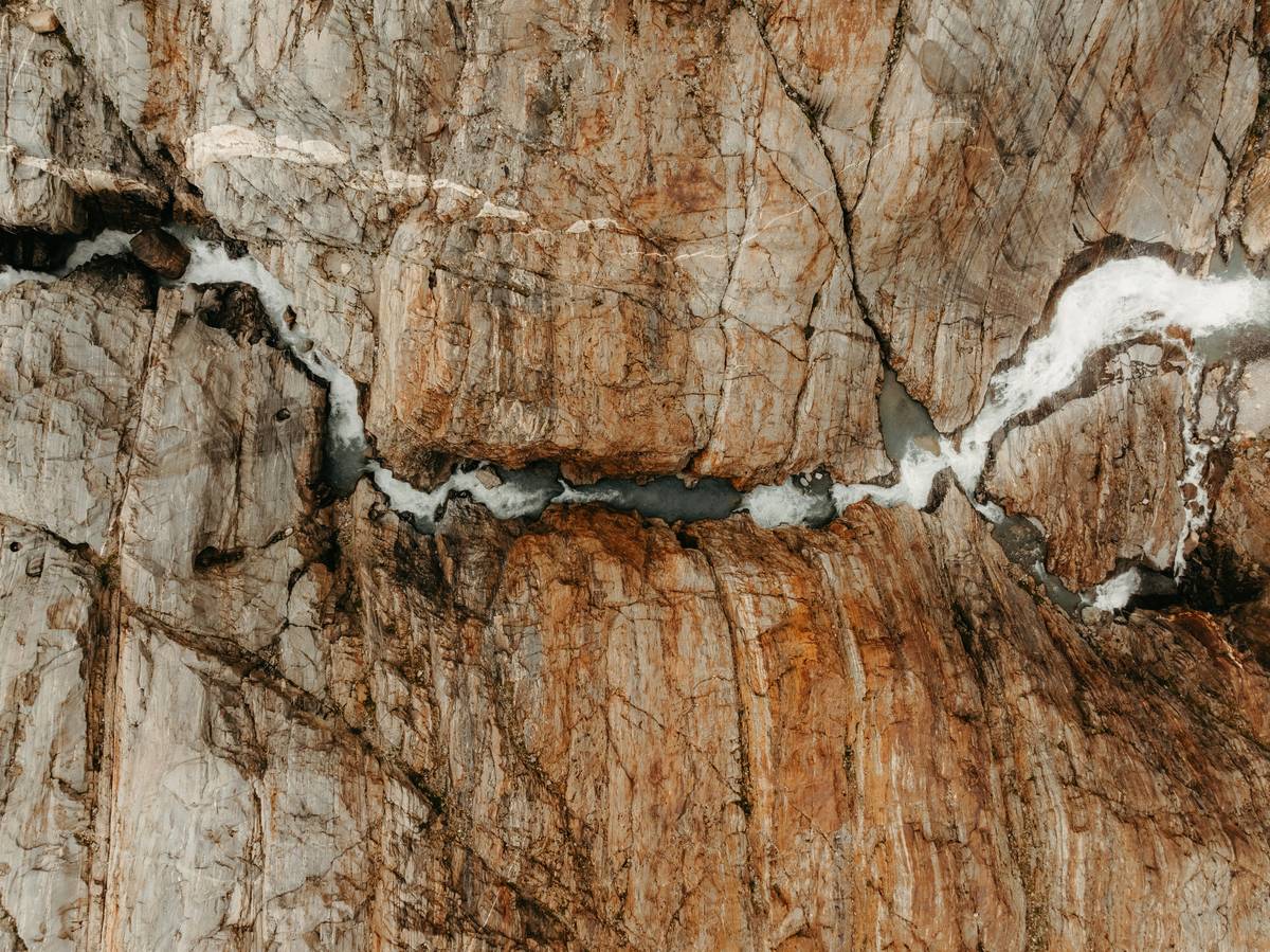 Close-up of a climber using an offset piton in a thin crack