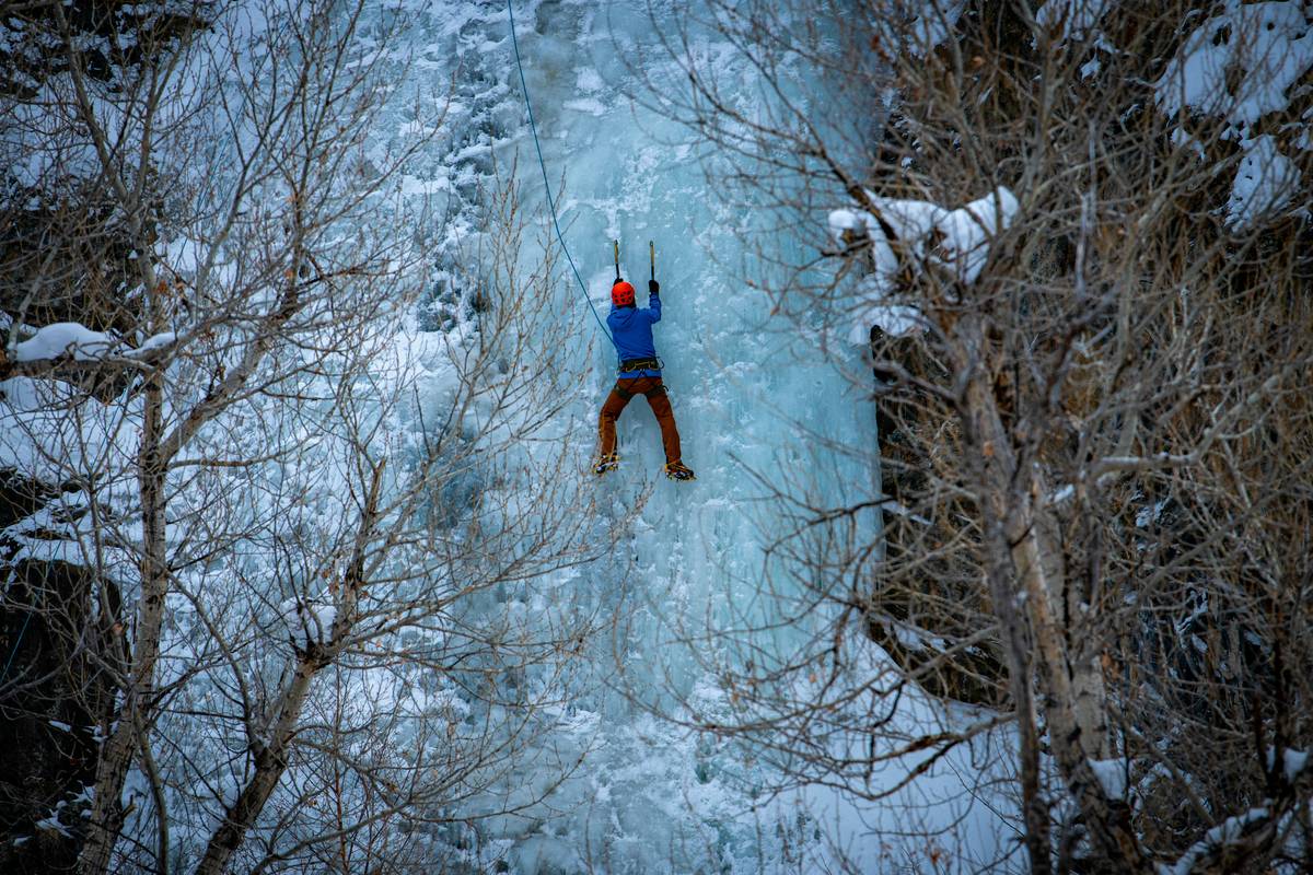 A climber tackling steep neve ice using pitons