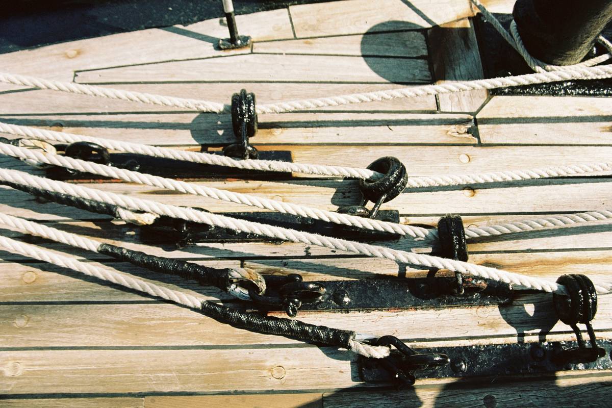 An old-school climber hammering a steel piton into a rock face.