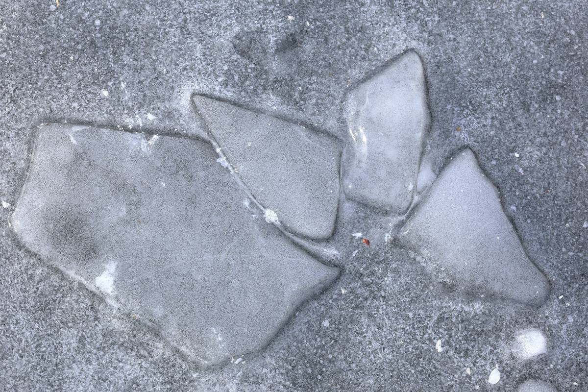 Climber hammering a piton into an icy crevice