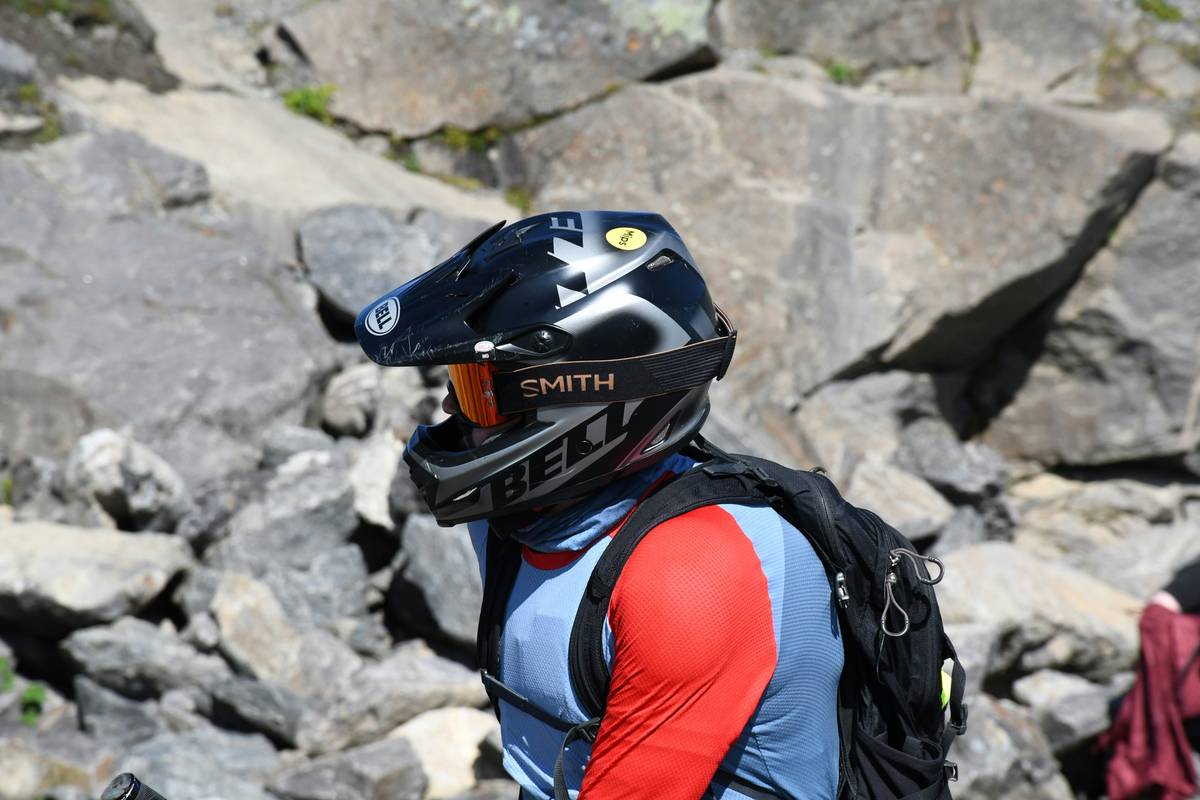 Climber preparing rappel piton anchor steel against rocky terrain
