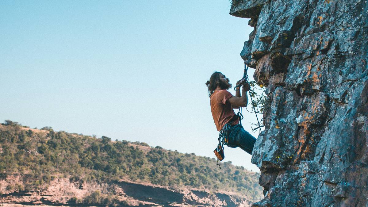 Climber scaling El Capitan using classic piton placements
