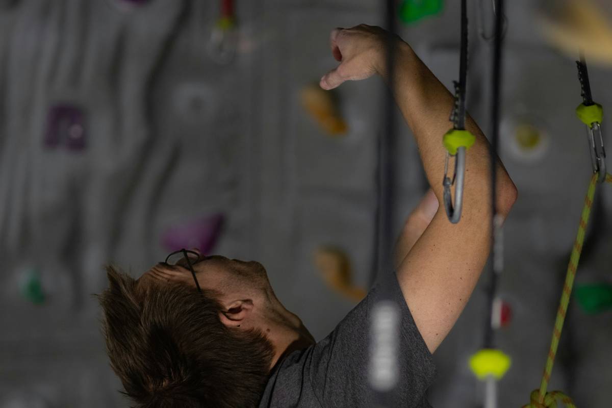 Illustration demonstrating three stages of testing climbing pitons using weights and tension devices.