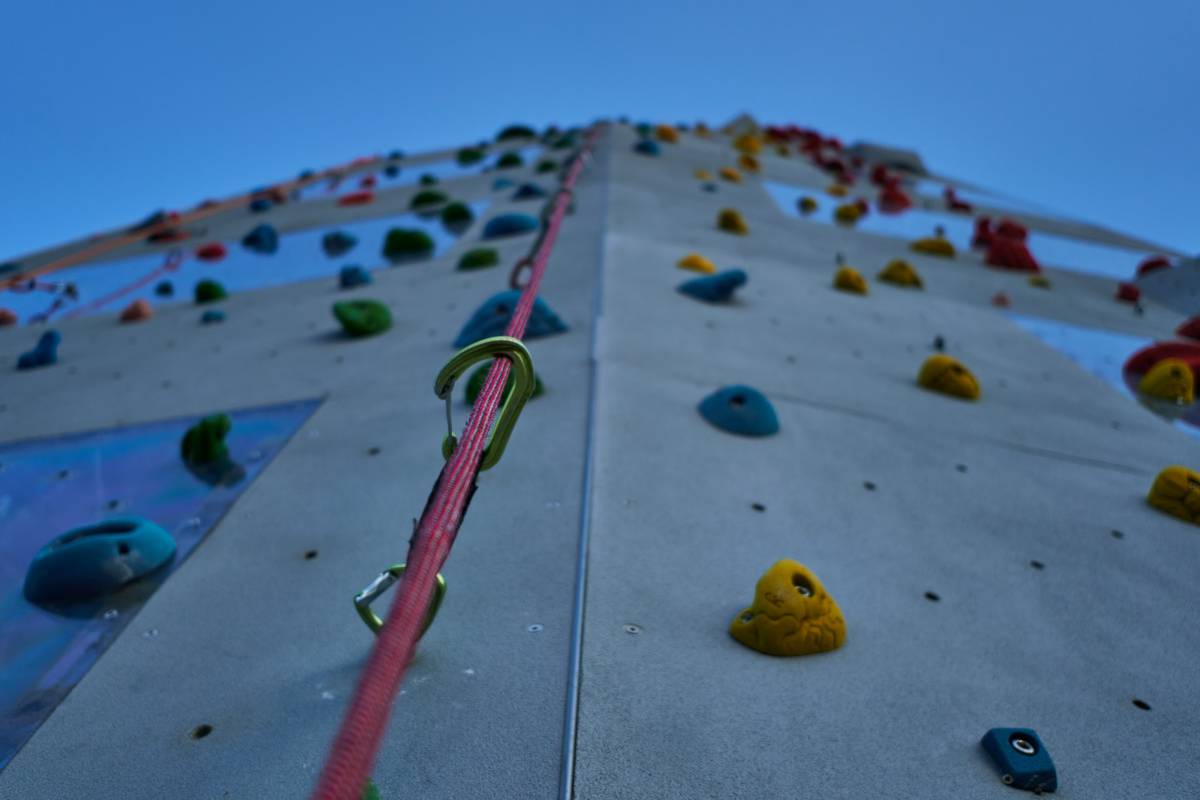 Various types of climbing pitons laid out on a rock surface