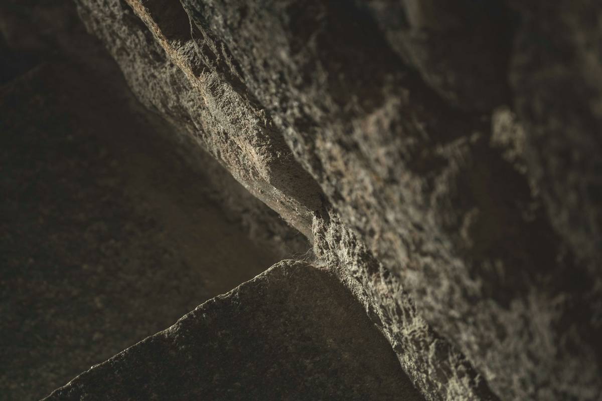 A climber placing a steel piton into an offwidth crack